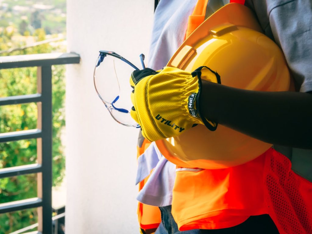 Construction worker with safety gear including helmet and gloves.